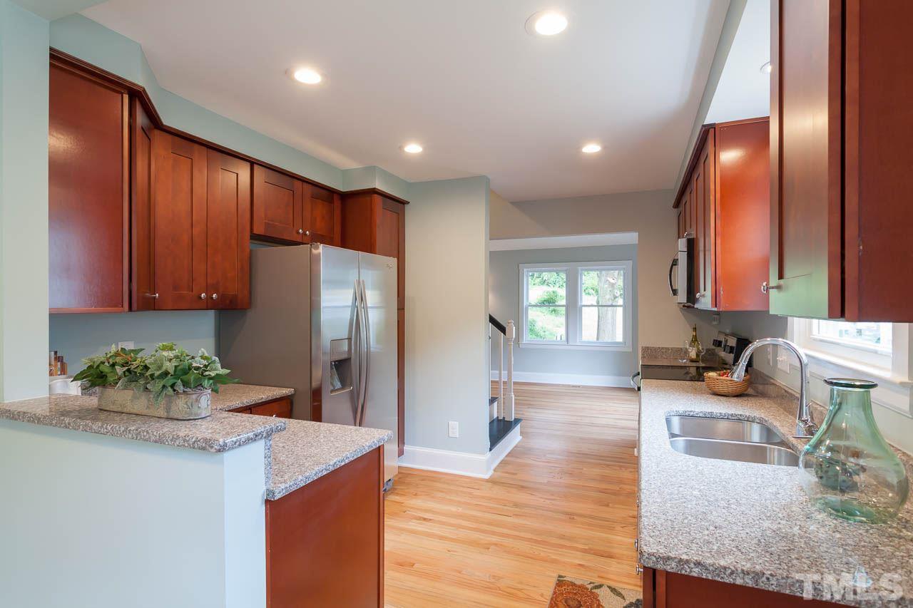 1113 Fairview Street Durham, NC 27707 - Photo 10 of 25 a kitchen with stainless steel appliances granite countertop wooden floor a refrigerator and a sink