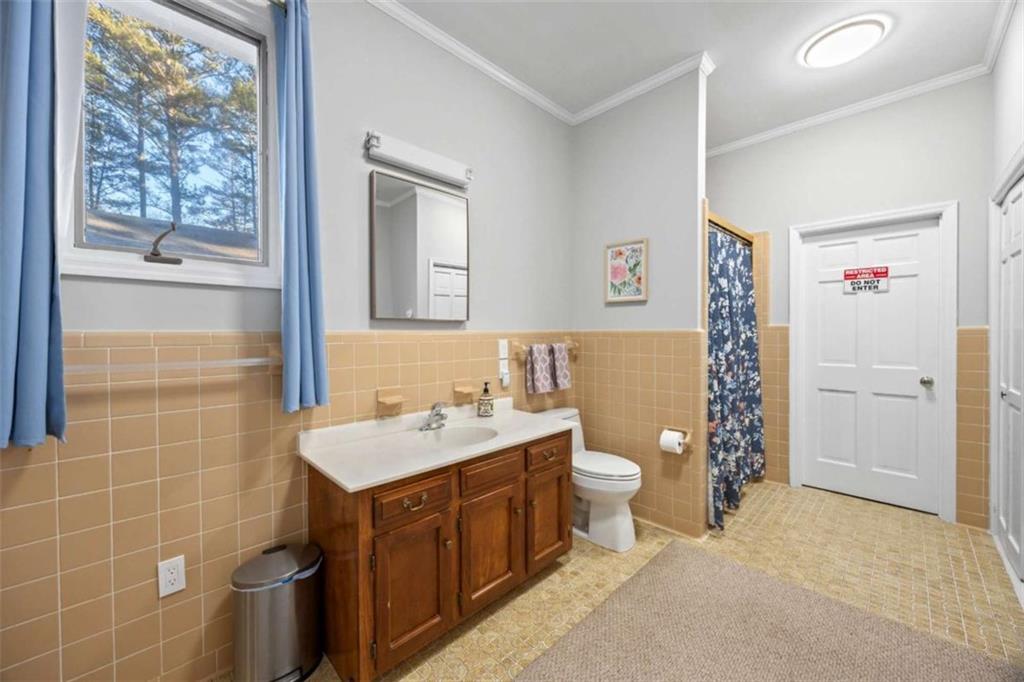 200 McGuirts Bridge Road Covington, GA 30014 - Photo 16 of 100 a bathroom with a double vanity sink toilet and shower