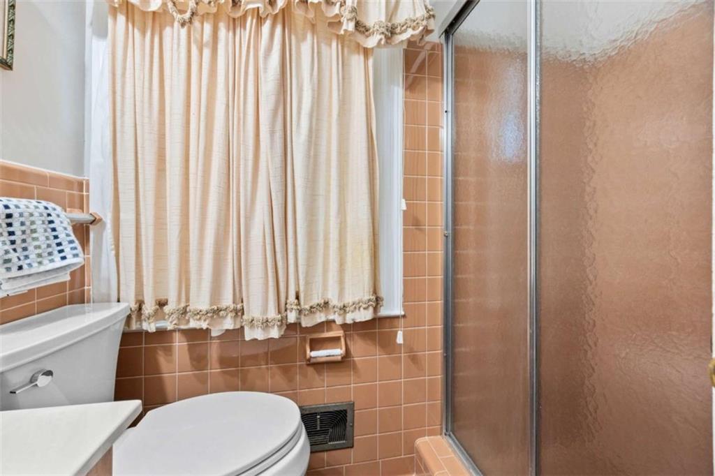 200 McGuirts Bridge Road Covington, GA 30014 - Photo 54 of 100 a bathroom with a sink a toilet a mirror and shower