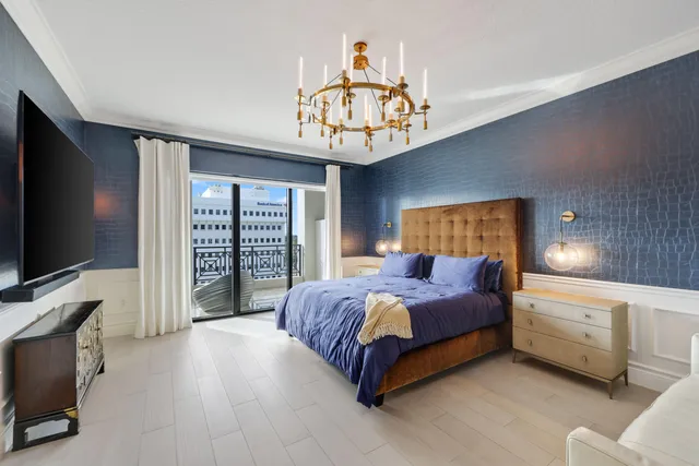 a spacious bedroom with a bed and a flat screen tv