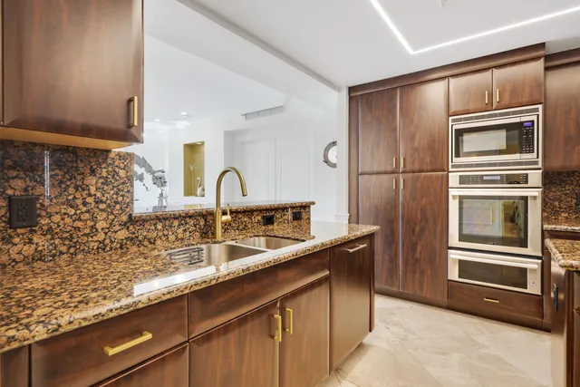a kitchen with stainless steel appliances granite countertop a sink and a refrigerator