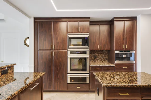 a kitchen with granite countertop stainless steel appliances and wooden cabinets