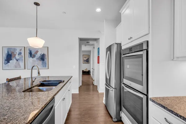 a kitchen with stainless steel appliances granite countertop a refrigerator a sink and a stove