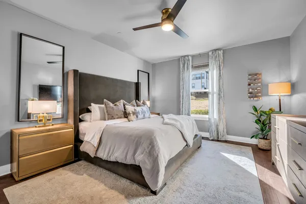a spacious bedroom with a bed and a chandelier