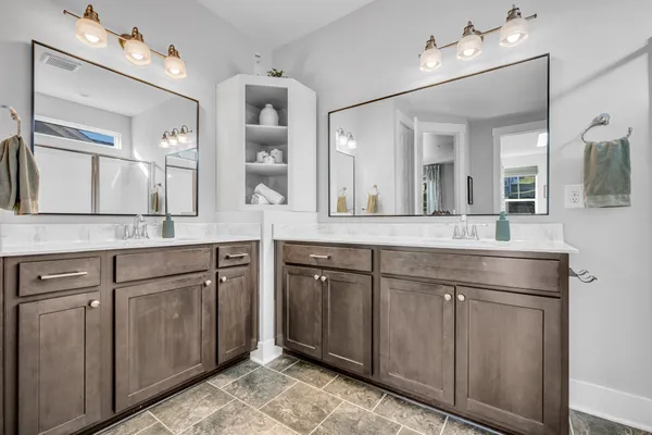 a bathroom with a granite countertop sink mirror and cabinets