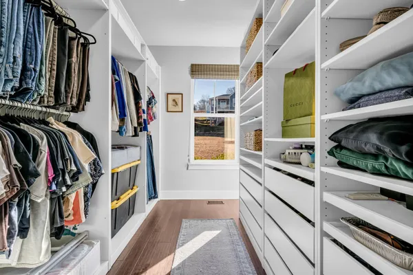 a view of walk in closet with clothes and shoes