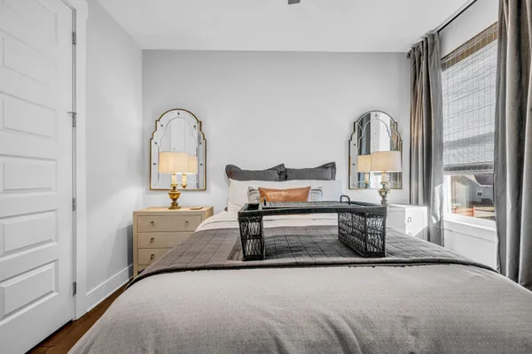 a bedroom with a bed and a dresser with mirror