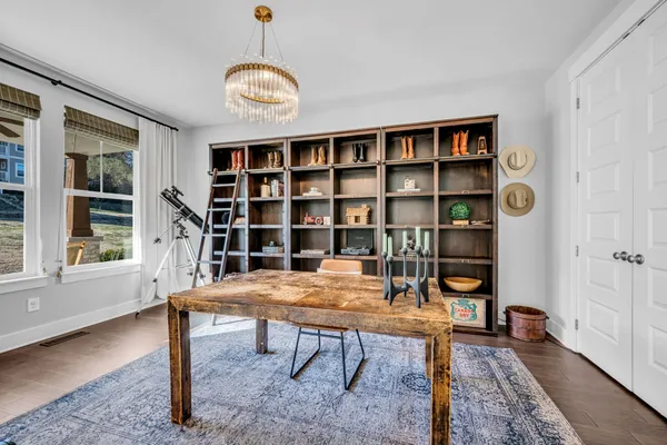 a view of a workspace with furniture and a window