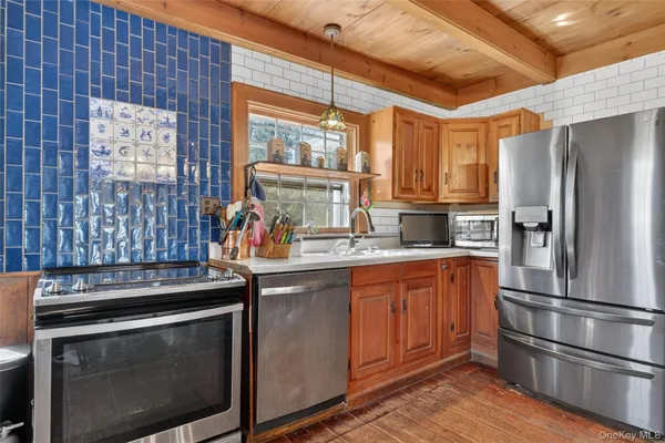 a kitchen with stainless steel appliances granite countertop a stove a refrigerator and a sink