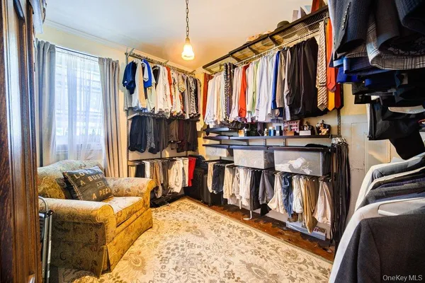 a view of walk in closet with clothes and shoes
