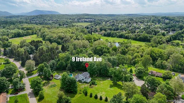 an aerial view of residential house with outdoor space and trees all around