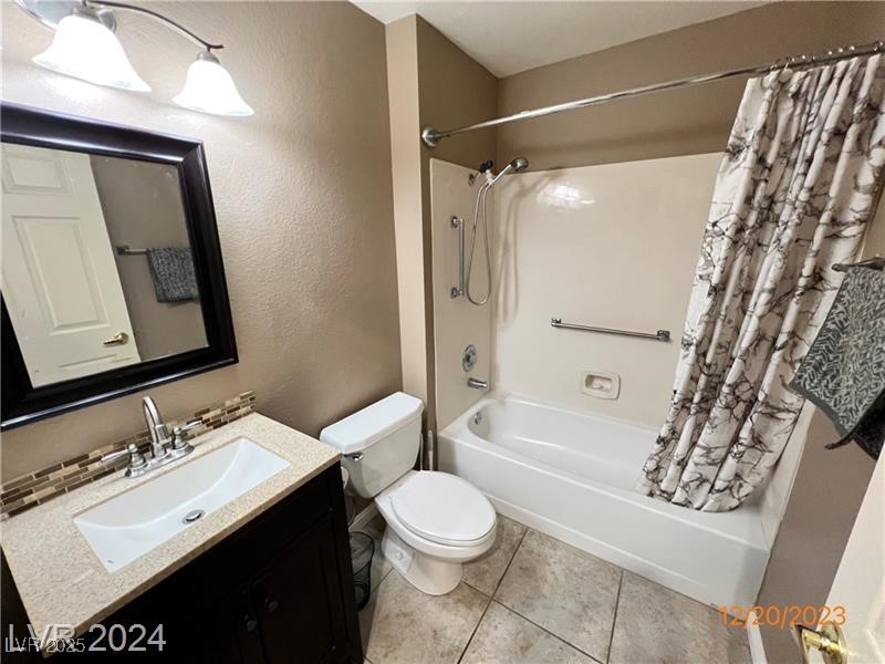 9436 Quail Ridge Drive Las Vegas, NV 89134 - Photo 12 of 17 Bathroom featuring shower / bath combo with shower curtain, vanity, tile patterned flooring, and a textured wall