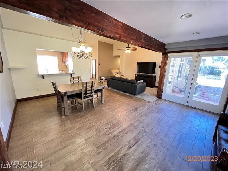9436 Quail Ridge Drive Las Vegas, NV 89134 - Photo 6 of 17 Dining room featuring beam ceiling, wood finished floors, healthy amount of natural light, a chandelier, and french doors