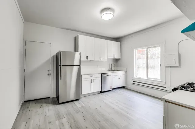 a kitchen with stainless steel appliances a refrigerator sink and cabinets