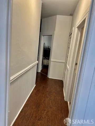 a kitchen with stainless steel appliances granite countertop a stove a sink dishwasher and white cabinets with wooden floor