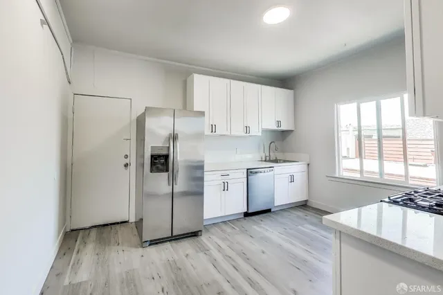 a kitchen with stainless steel appliances a refrigerator sink and cabinets