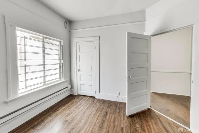 wooden floor in an empty room with a window