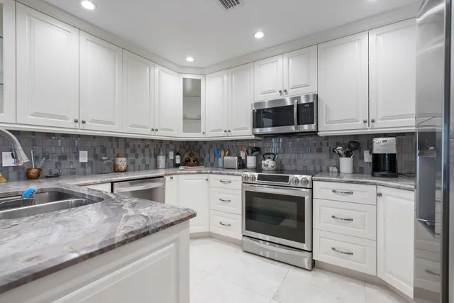 a kitchen with stainless steel appliances granite countertop a stove and a microwave