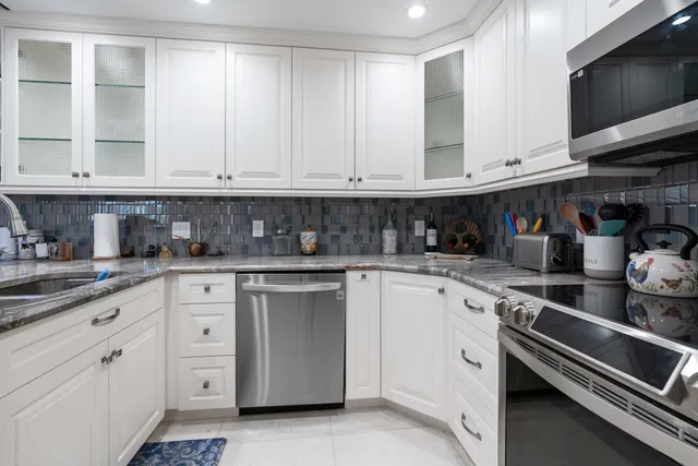 a kitchen with a sink and a flat screen tv