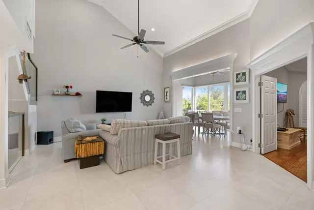 a living room with furniture a flat screen tv and a floor to ceiling window