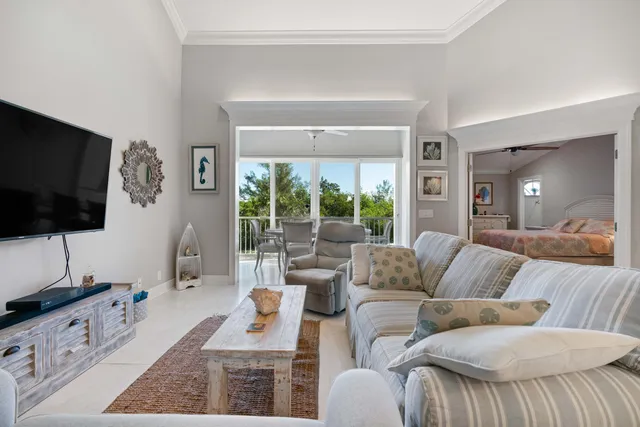 a living room with furniture wooden floor and a large window