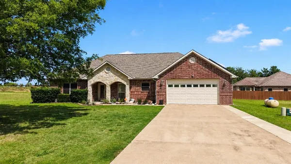 a front view of a house with yard and green space