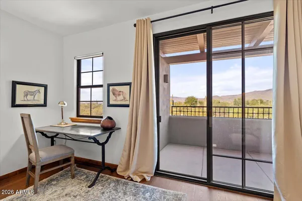 a view of a workspace with furniture and a window