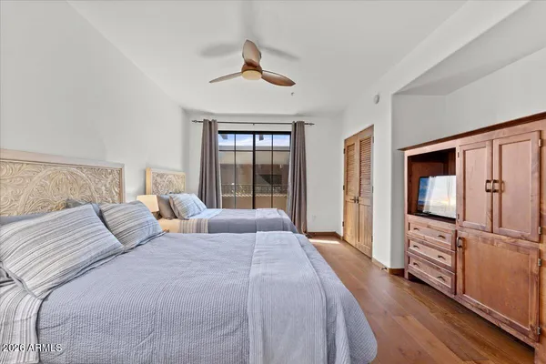 a bedroom with a bed flat screen tv and a large window