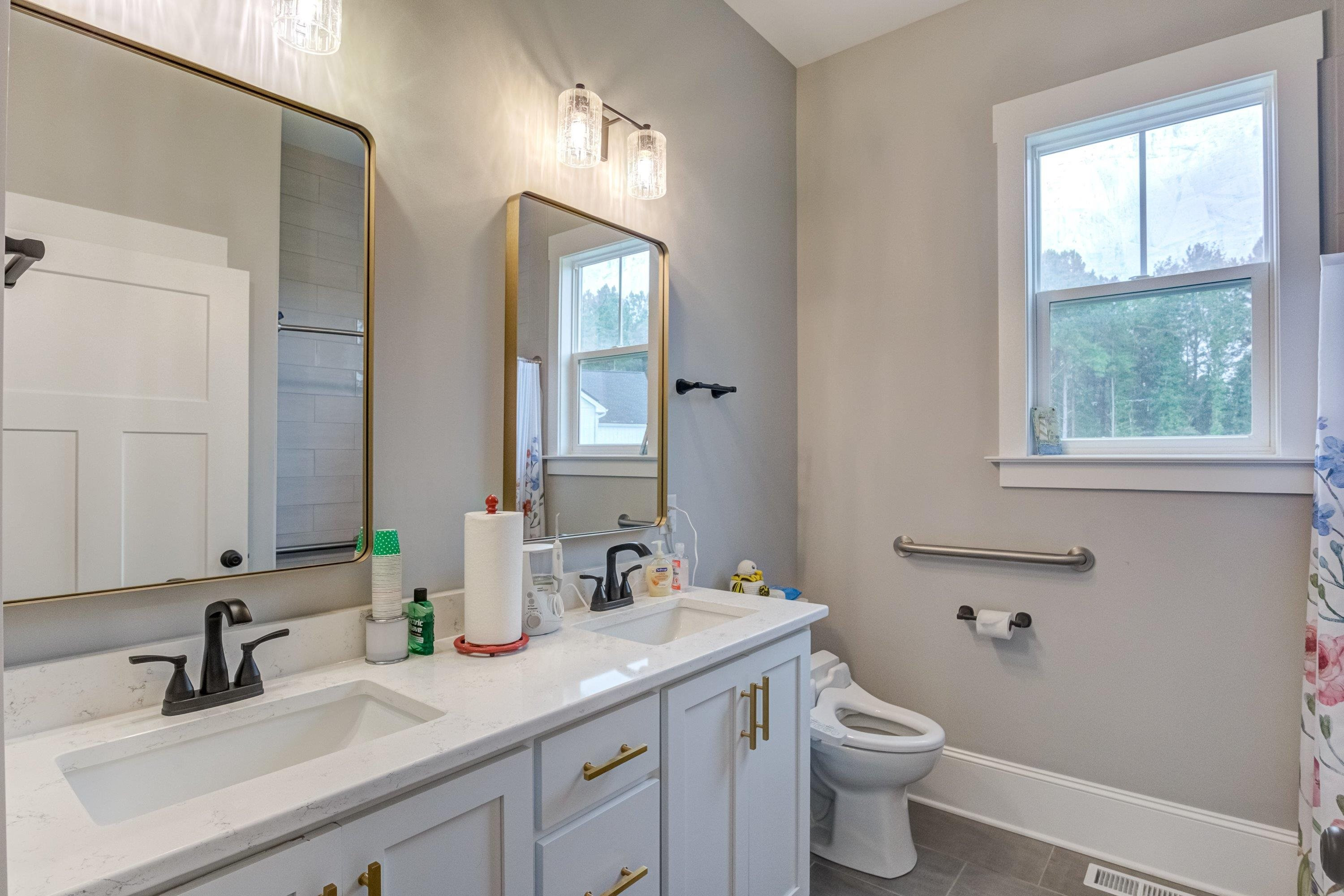 109 Independence Drive Smithfield, NC 27577 - Photo 24 of 36 a bathroom with a double vanity sink toilet and a mirror