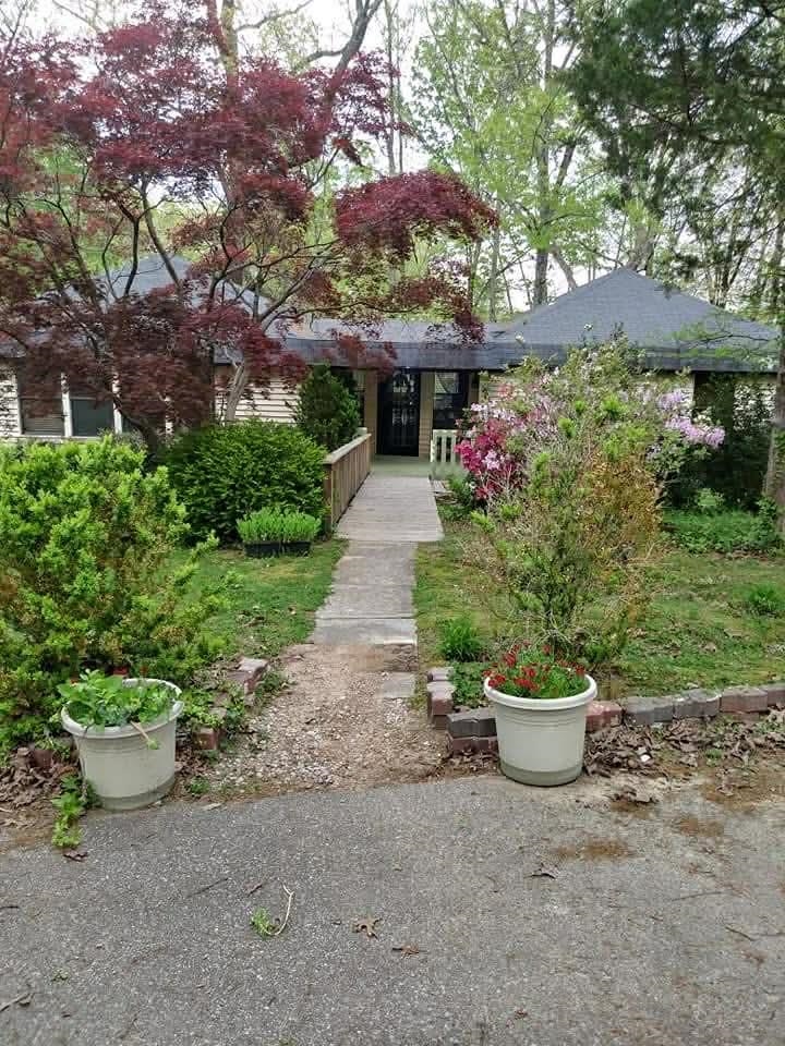 1655 Country Club Road Somerville, TN 38068 - Photo 13 of 26 a front view of a house with a yard and potted plants