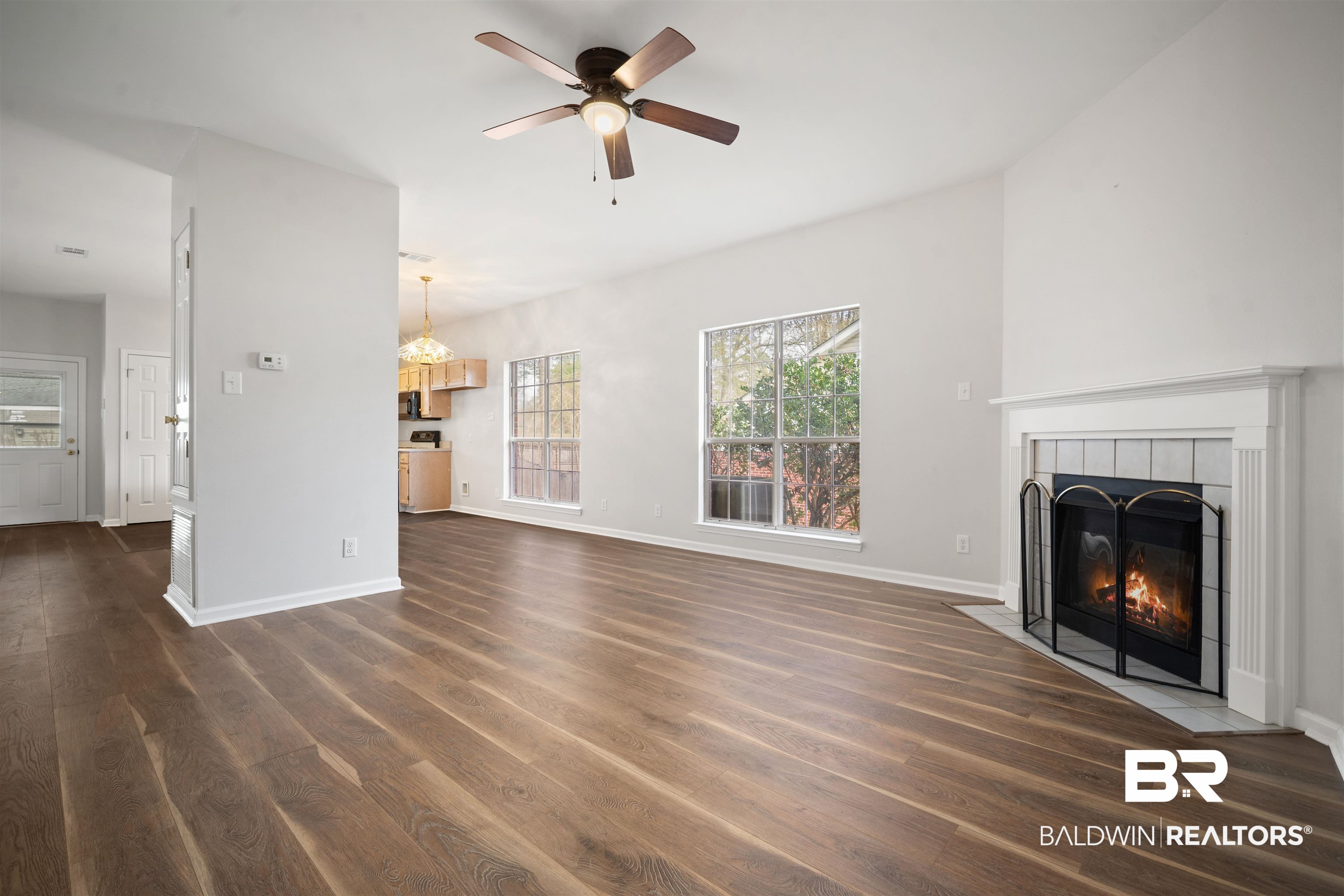 250 North Spring Lake Drive Mobile, AL 36695 - Photo 5 of 29 Unfurnished living room with dark wood-type flooring, a tile fireplace, and a ceiling fan