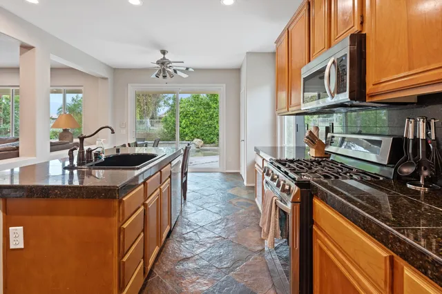 a kitchen with stainless steel appliances granite countertop a sink stove and cabinets
