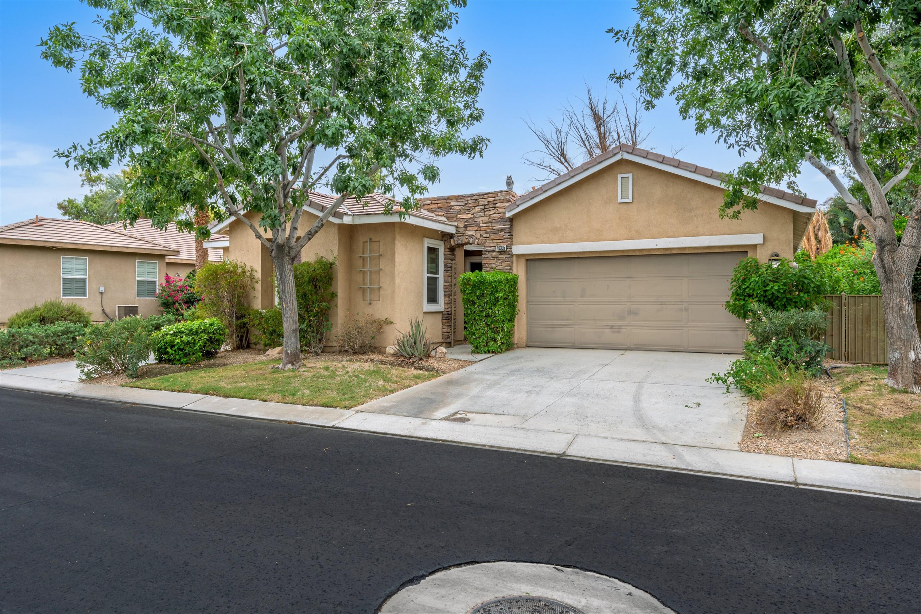 49335 Douglas Street Indio, CA 92201 - Photo 2 of 31 a front view of a house with a yard and garage