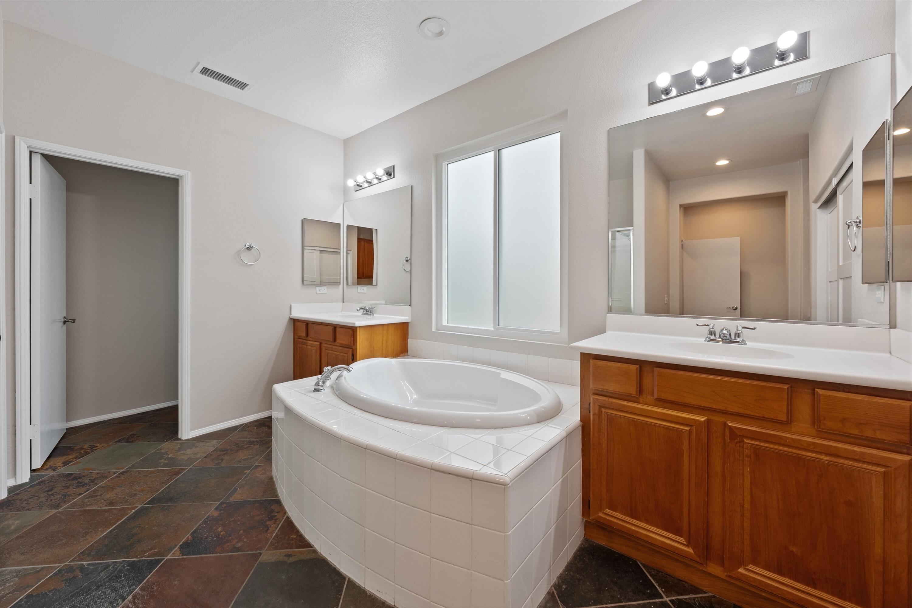 49335 Douglas Street Indio, CA 92201 - Photo 25 of 31 a spacious bathroom with a sink toilet a mirror and vanity