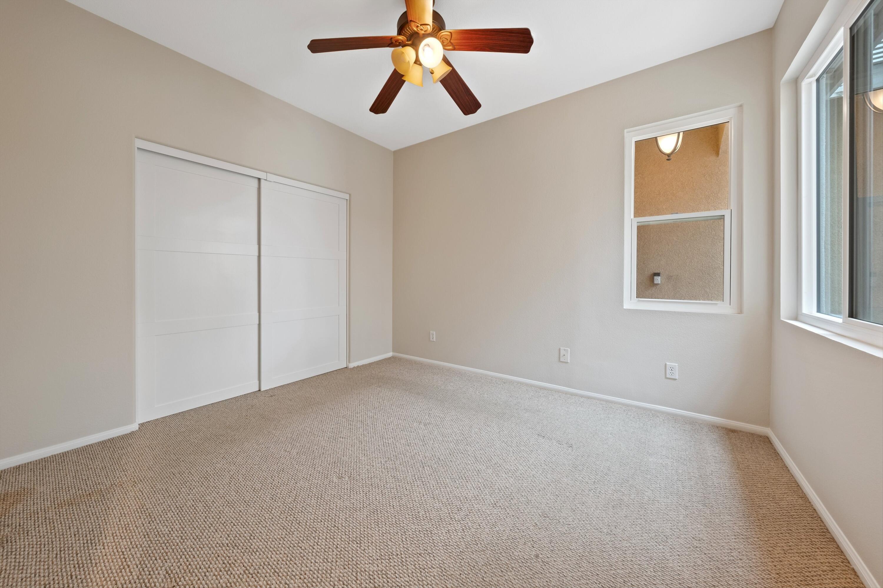 49335 Douglas Street Indio, CA 92201 - Photo 28 of 31 an empty room with chandelier fan and windows
