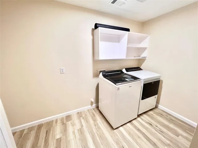 a utility room with wooden floor washer and dryer