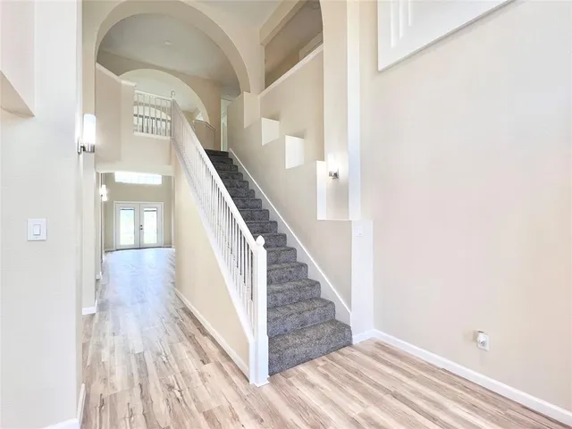 a view of a hallway with wooden floor and staircase