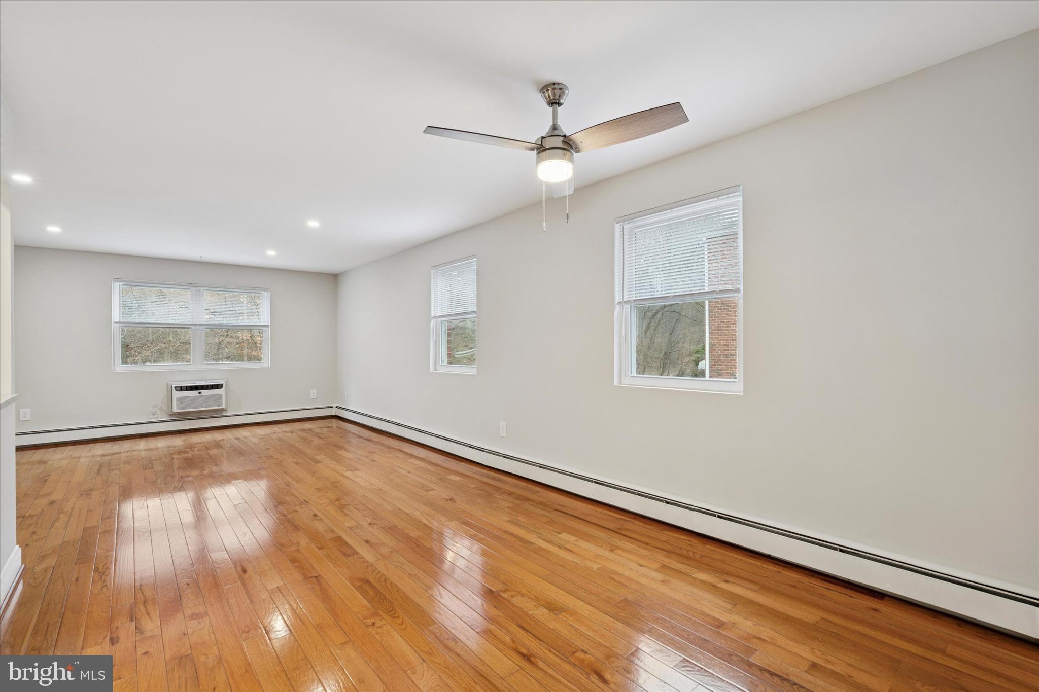508 Stidman Drive, Unit C1 Springfield, PA 19064 - Photo 5 of 21 an empty room with wooden floor fan and windows