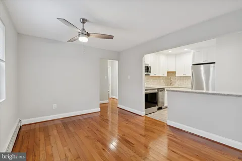a view of a kitchen with wooden floor and a ceiling fan