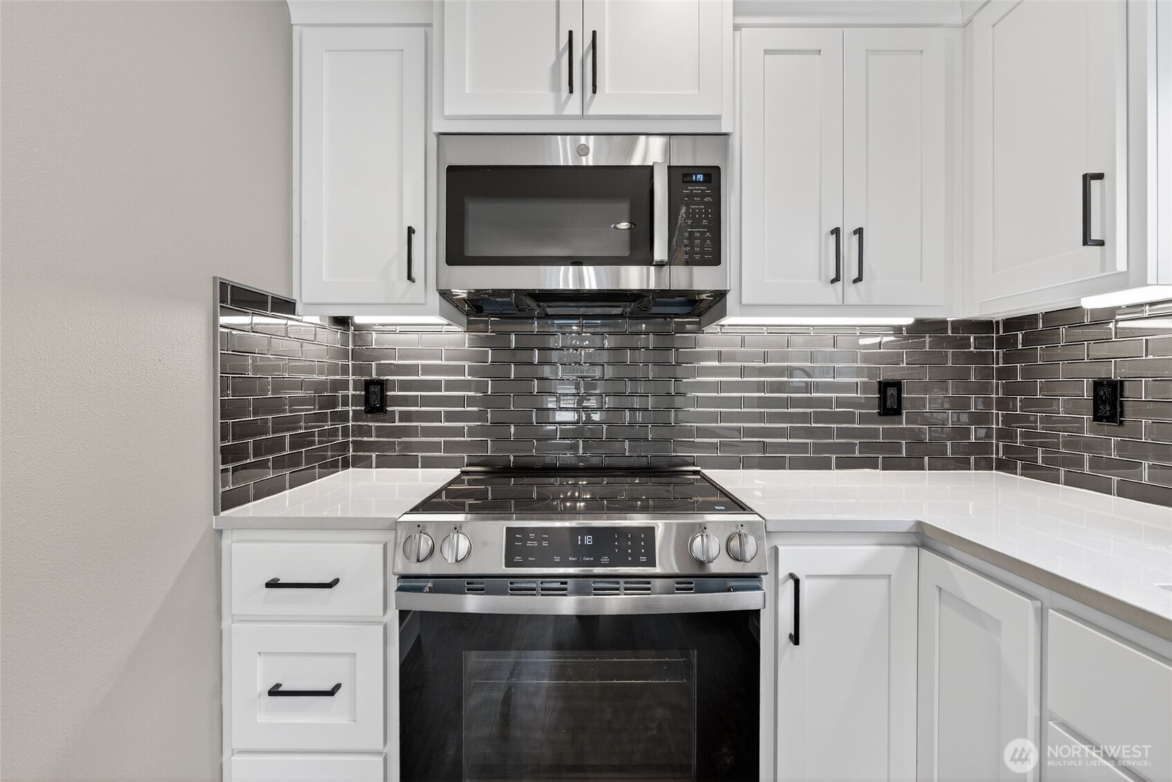 111 7th Street Southwest Long Beach, WA 98631 - Photo 10 of 30 a kitchen with granite countertop white cabinets and stainless steel appliances