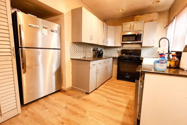 a kitchen with stainless steel appliances granite countertop a refrigerator sink and microwave