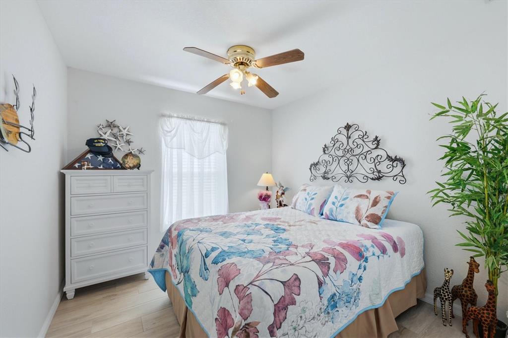 4036 Elvington Road Port Charlotte, FL 33981 - Photo 19 of 29 a bedroom with a bed and a chandelier