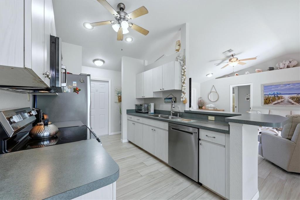 4036 Elvington Road Port Charlotte, FL 33981 - Photo 25 of 29 a kitchen with stainless steel appliances granite countertop a sink a stove and a refrigerator
