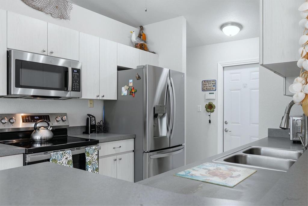 4036 Elvington Road Port Charlotte, FL 33981 - Photo 5 of 29 a kitchen with stainless steel appliances a refrigerator sink and microwave