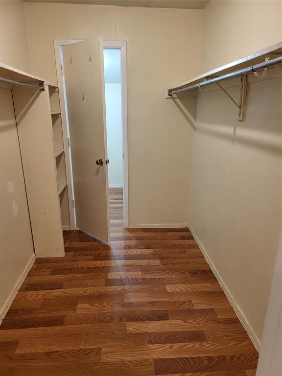 6900 Skillman Street, Unit 111 Dallas, TX 75231 - Photo 10 of 25 a view of an empty room with wooden floor and a ceiling fan