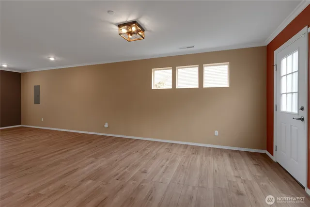 a view of empty room with wooden floor and window