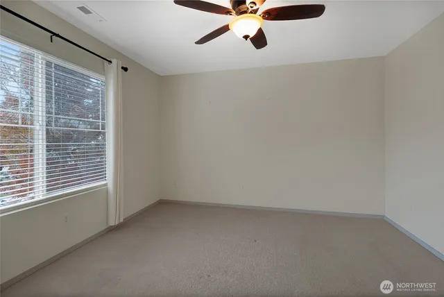 en empty room with window and ceiling fan