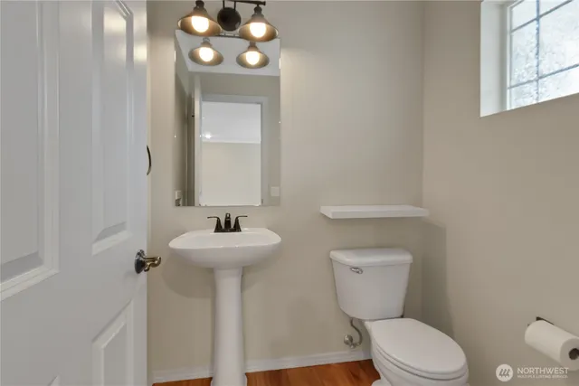 a bathroom with a toilet sink and mirror