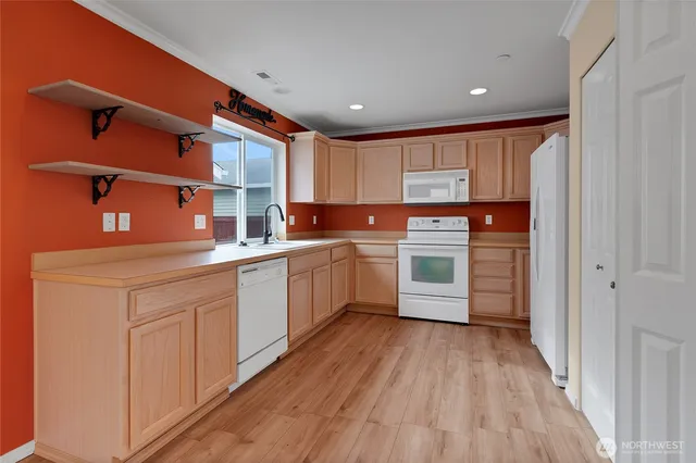 a kitchen with stainless steel appliances granite countertop a sink cabinets and wooden floor