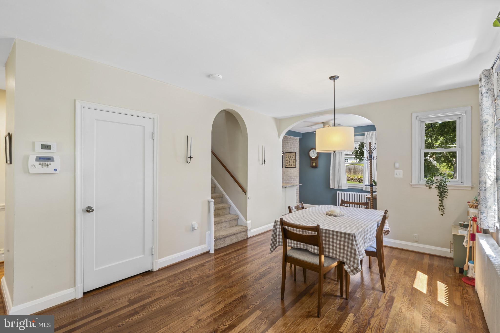 6500 Sharon Road Baltimore, MD 21239 - Photo 4 of 33 a dining room with wooden floor a chandelier a wooden table and chairs